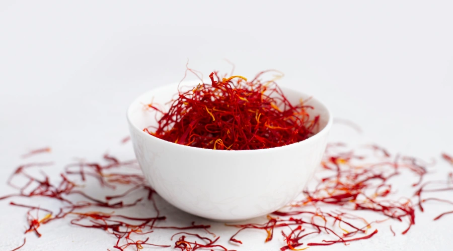 Bowl filled with premium Kashmiri saffron threads placed on a white background.